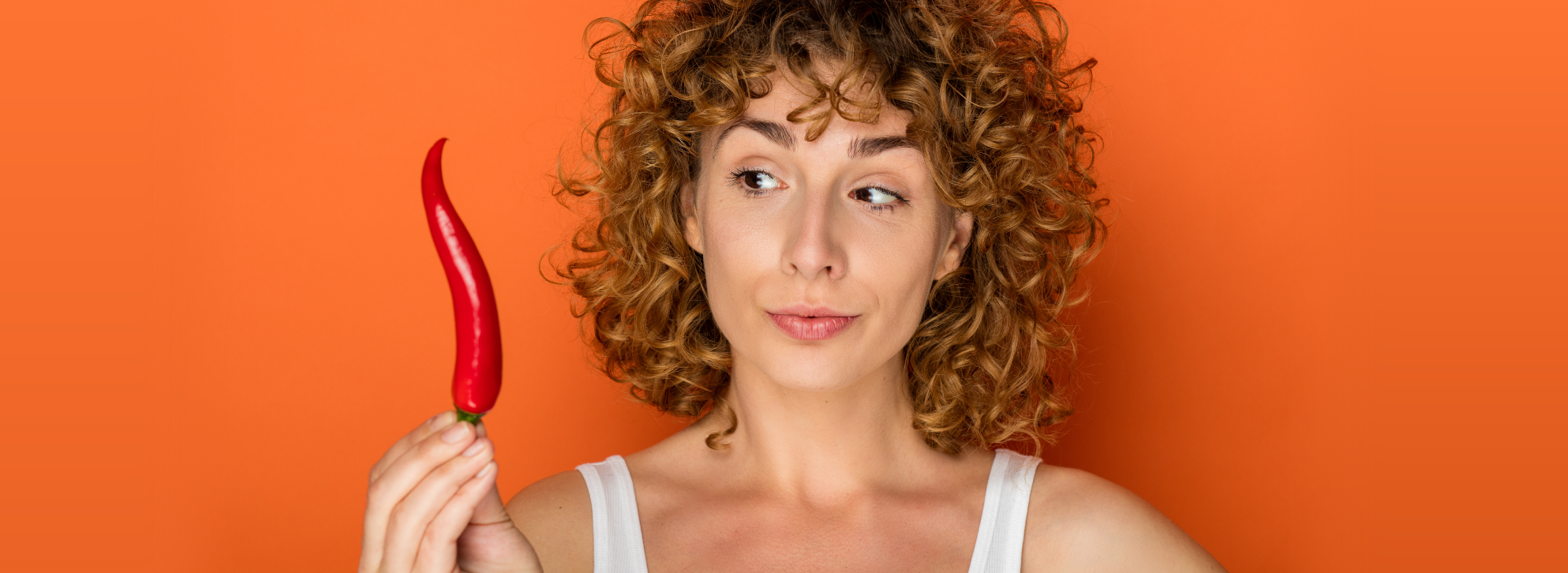 Woman holding up a hot pepper.