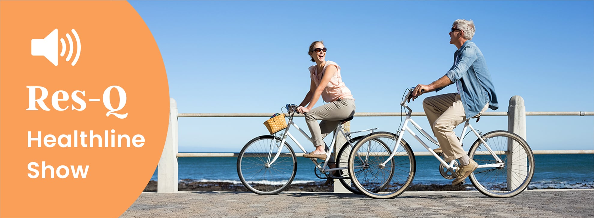 Middle-aged couple riding bike near the water