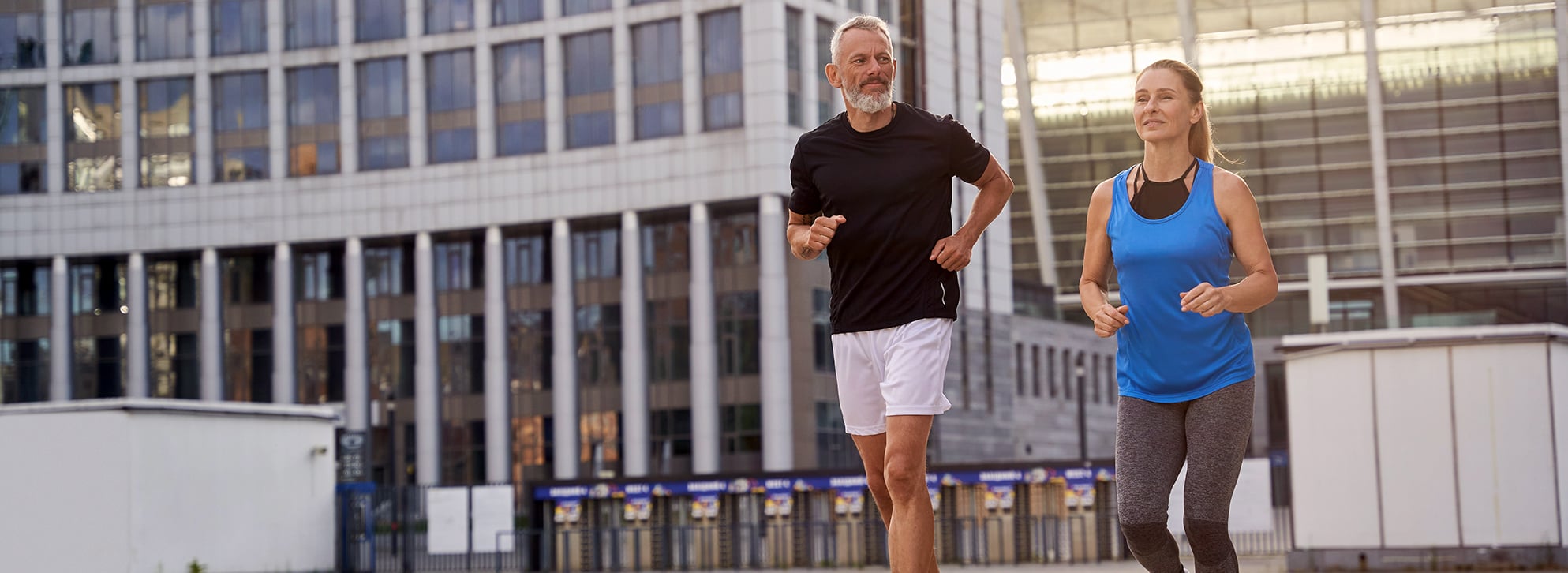 Middle-aged couple jogging in the city